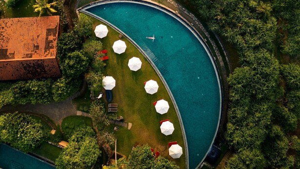 An aerial view of a resort with a swimming pool, beach, and lush greenery. - Cape Weligama - Relais and Chateaux (Weligama)