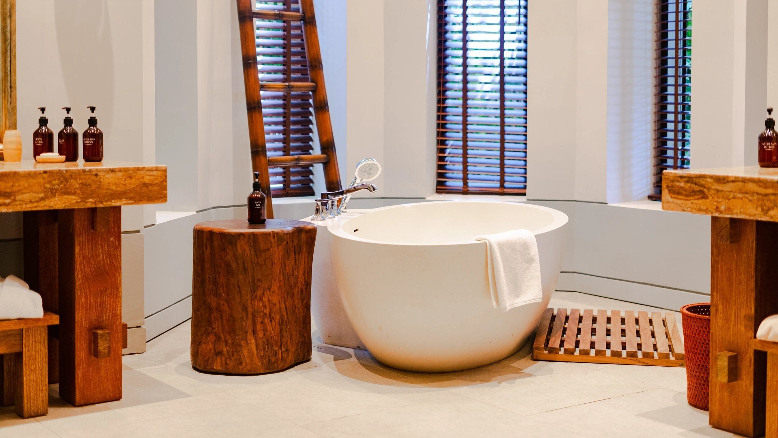 Ein modernes Badezimmer mit freistehender Badewanne, Holzwaschtisch und einem großen Spiegel.