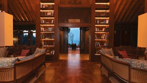 A spacious library with high wooden bookshelves and comfortable seating areas. - Cape Weligama - Relais and Chateaux (Weligama)