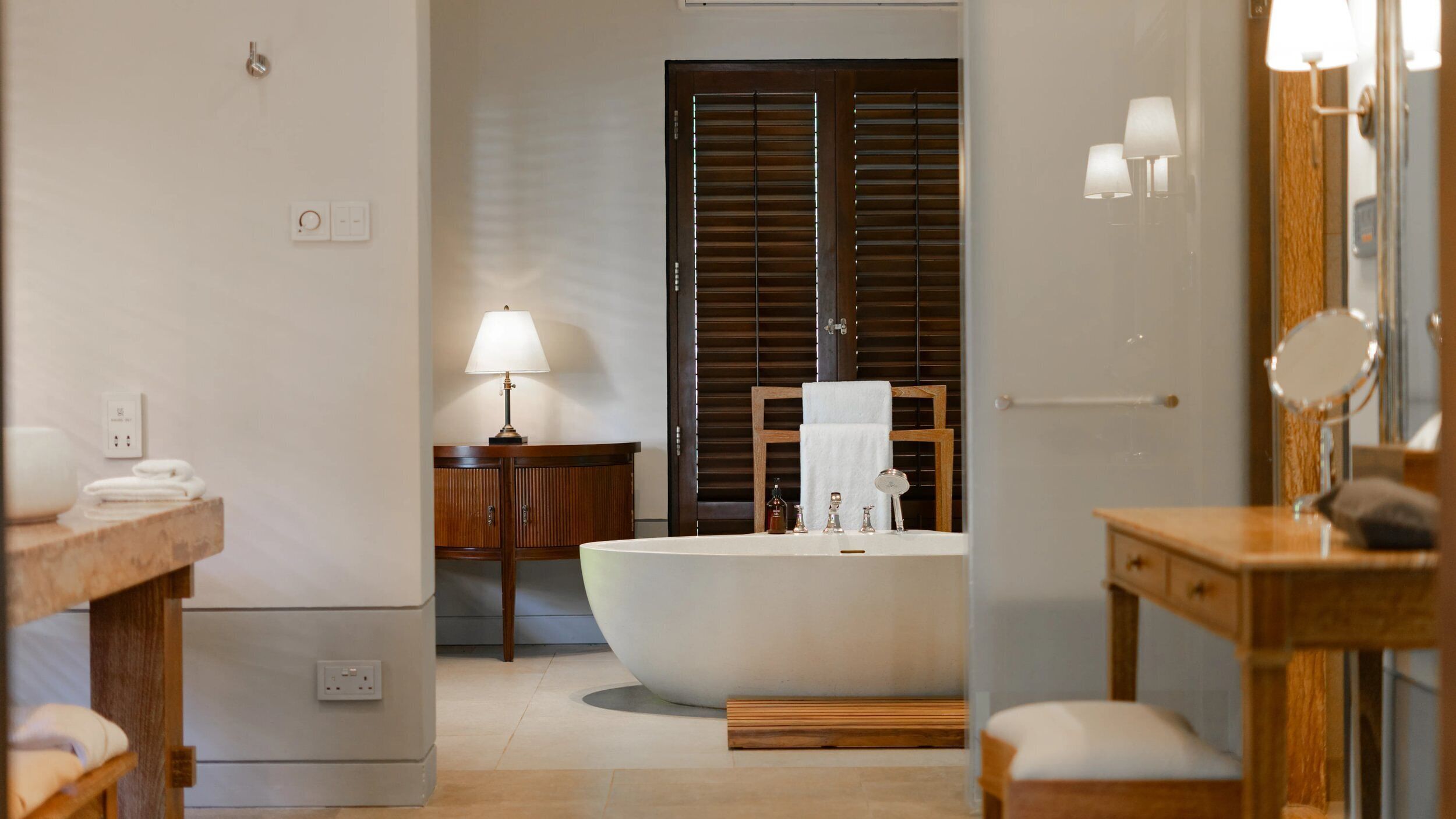 Une salle de bain moderne avec une baignoire sur pieds, un meuble-lavabo en bois et un miroir.