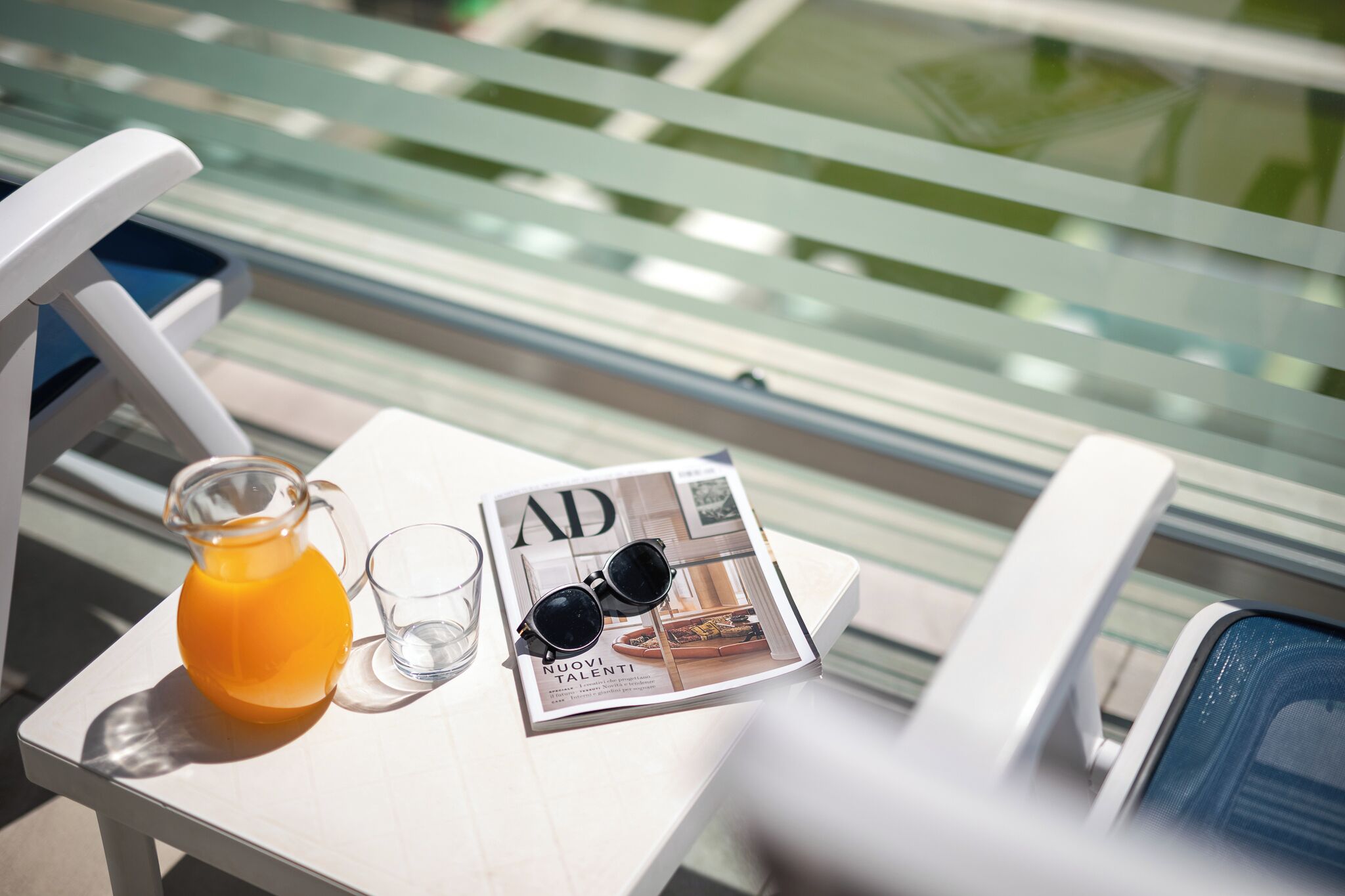 A table with a magazine, a glass pitcher, and a glass.
