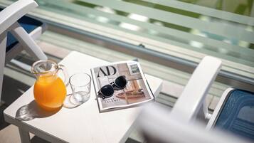 A table with a magazine, a glass pitcher, and a glass.