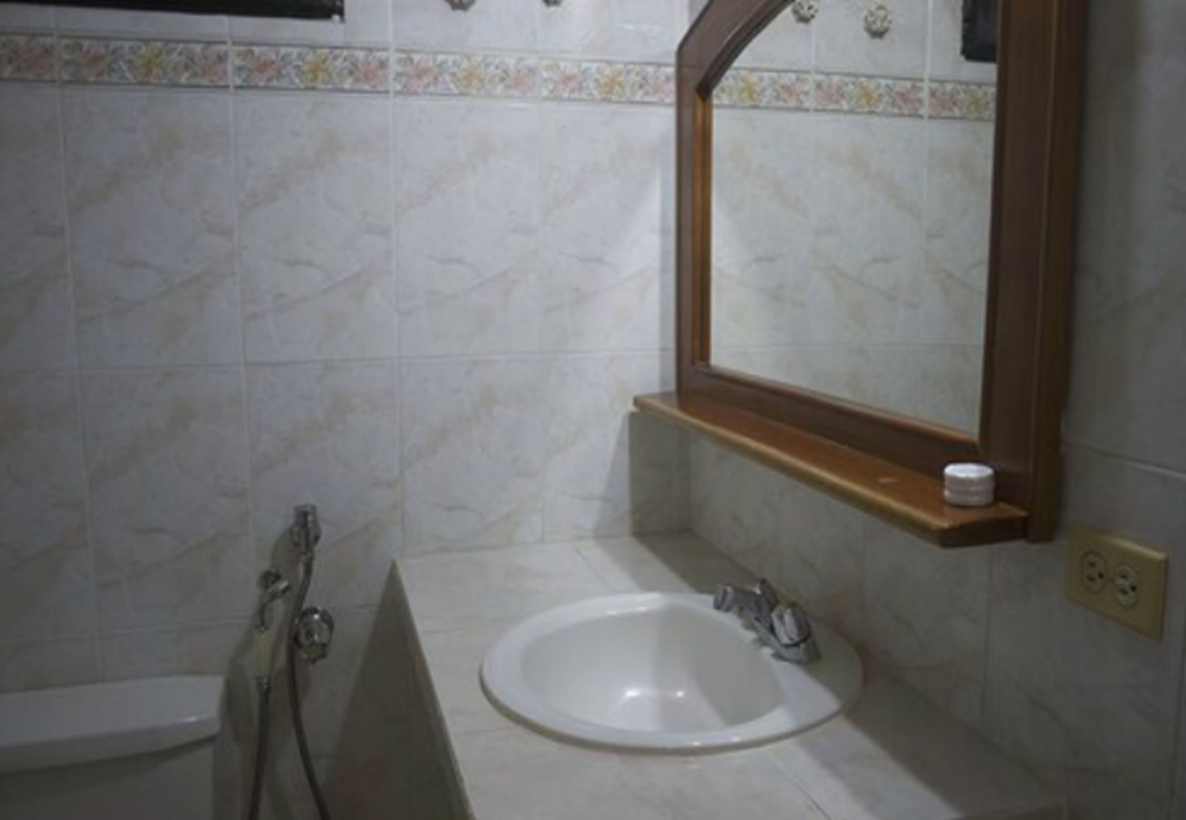 A bathroom with a white sink, a mirror, and a shower.