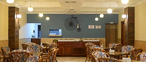 A dining area with wicker chairs and a central island with a sink.