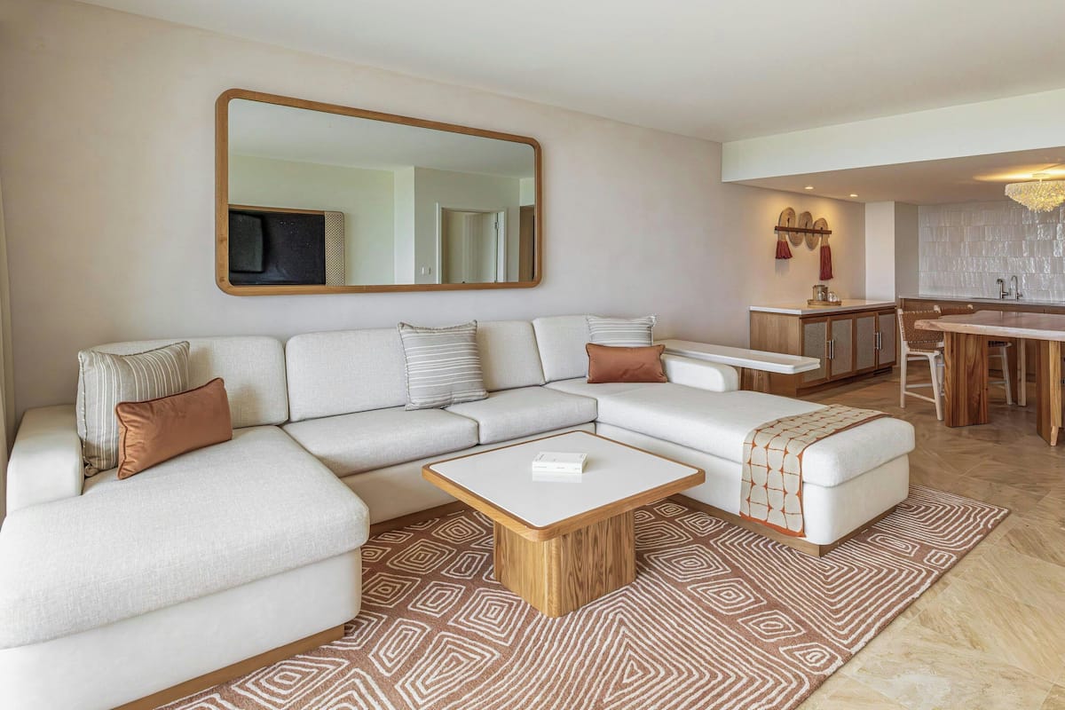 A modern living room with a sectional sofa, a wooden coffee table, and a patterned rug.