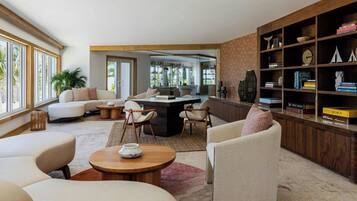 A modern living room with a sofa, chairs, a coffee table, and a bookshelf.