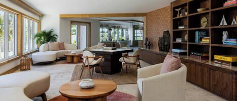 A modern living room with a sofa, chairs, a coffee table, and a bookshelf.