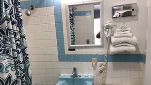 A bathroom with a blue sink, a toilet, a mirror, and a towel rack.