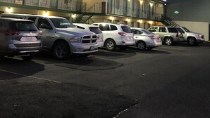 A motel with multiple rooms and a parking lot.