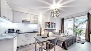 A modern bedroom with a large bed, a bedside table, and a window with a view. - Apartinfo Apartments - Sadowa (Gdansk)