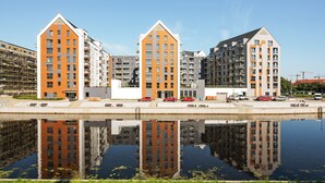 A modern apartment complex with a central courtyard and a reflective water feature. - Apartinfo Island Apartments (Gdansk)