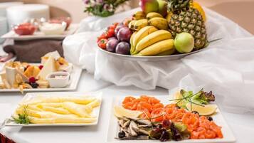 Una mesa de buffet con diversas opciones de comida, como frutas, quesos y ensaladas.