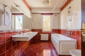 Un baño con dos lavamanos, una bañera y un inodoro.