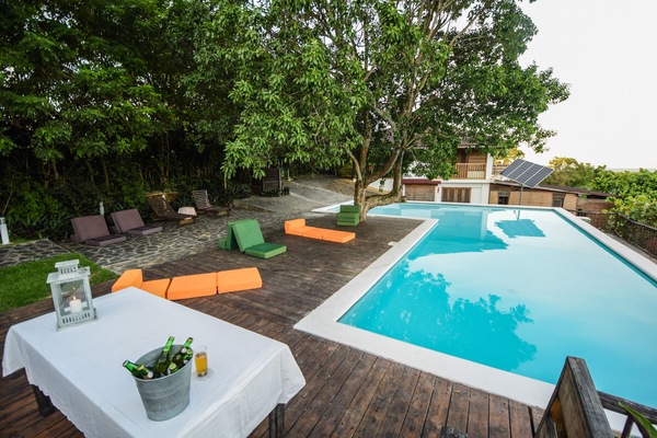 Una piscina al aire libre, sillones reclinables de piscina