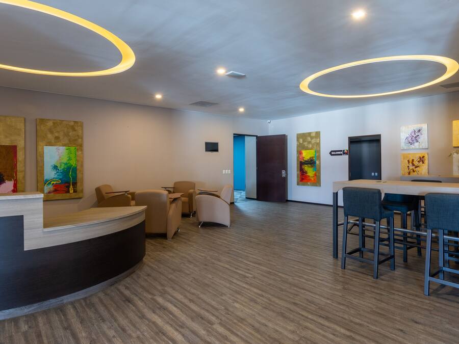A modern reception area with a curved desk, seating, and artwork on the walls.