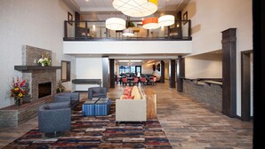 A spacious lobby with a fireplace, seating area, and a dining section. - Red Lion Inn & Suites Polson (Polson)