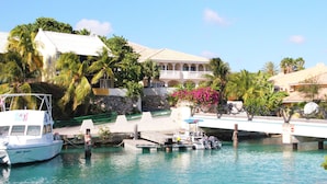 A marina with boats docked, a bridge, and a building with a balcony overlooking the water. - Ocean Apartments (Willemstad)
