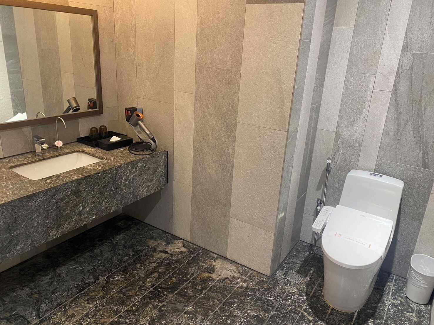 A bathroom with a sink, mirror, and toilet.