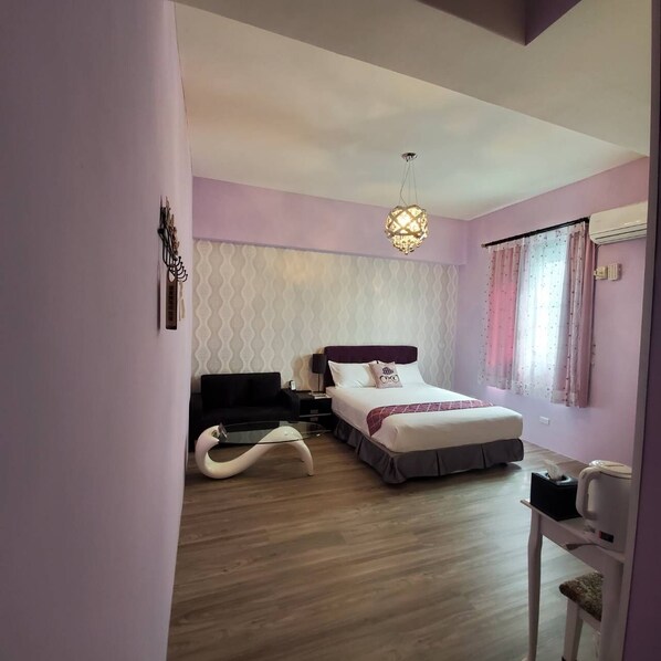 Un dormitorio con cama, mesita de noche, lámpara y una lámpara colgante.