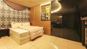 A bedroom with a bed, a vanity, and a large window. - Palace Motel (Incheon)