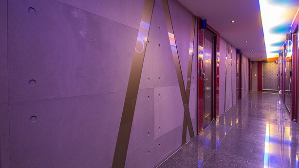 A modern hotel corridor with reflective floors and patterned walls. - Palace Motel (Incheon)