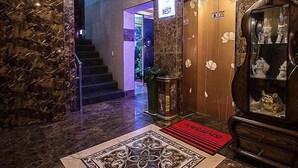 A marble-floored hallway with a red carpet leading to a door marked "BEST." - Palace Motel (Incheon)