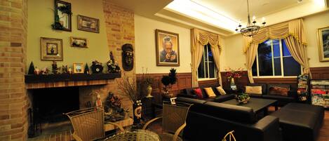 A cozy living room with a fireplace, comfortable seating, and a dining area.