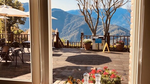 Una mesa con alimentos para el desayuno y vistas a montañas a través de una ventana.