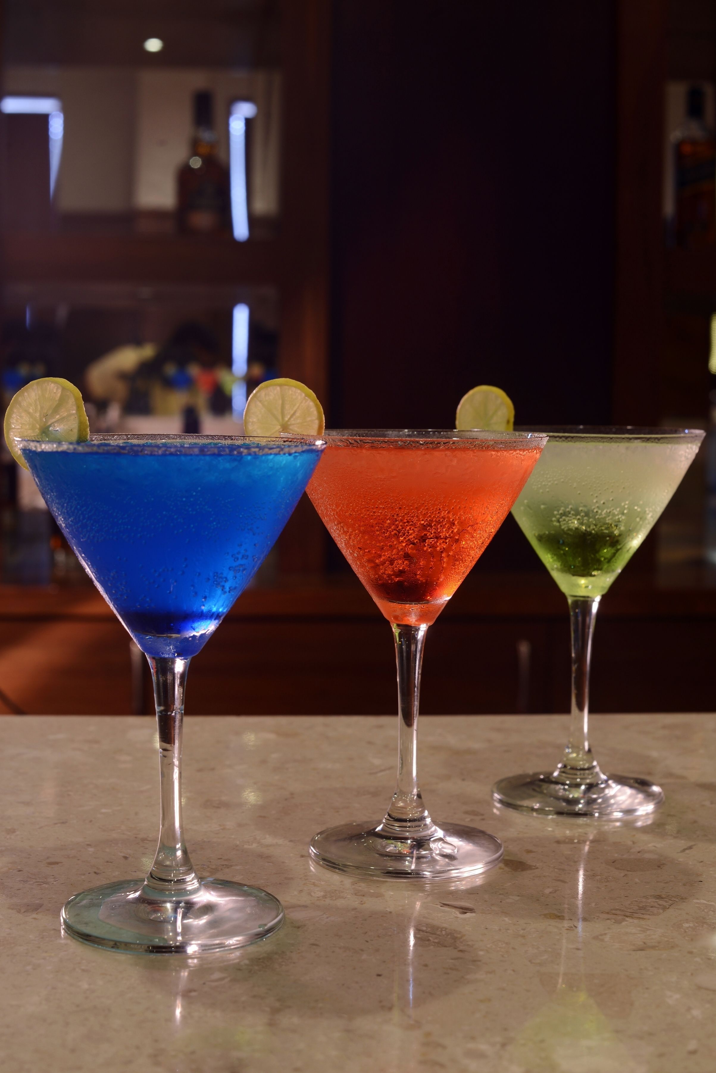 Tres vasos de martini sobre una superficie de mármol.