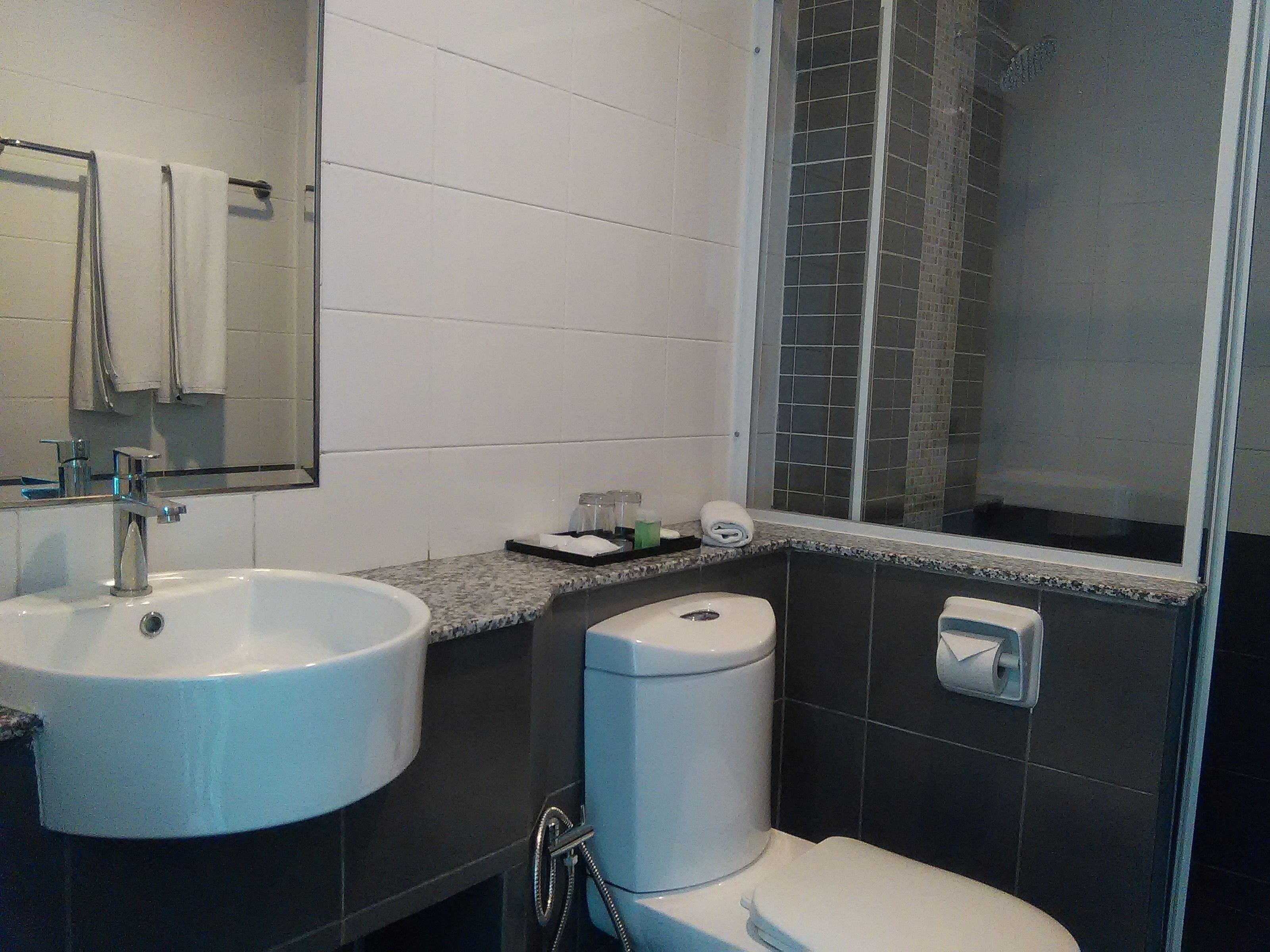 A bathroom with a sink, toilet, and shower.