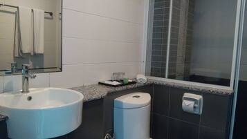 A bathroom with a sink, toilet, and shower.
