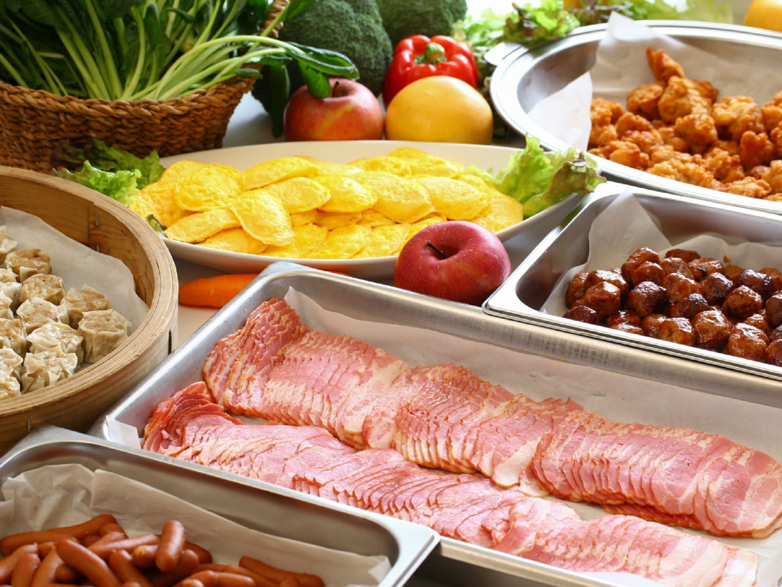 A buffet with various food items including ham, potatoes, and vegetables.