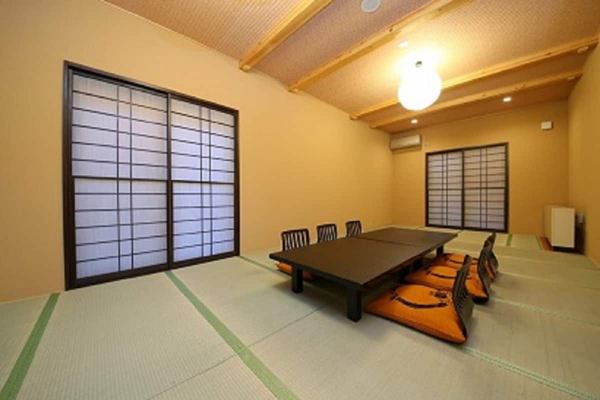 A traditional Japanese room with tatami flooring, a low table, and shoji screens.
