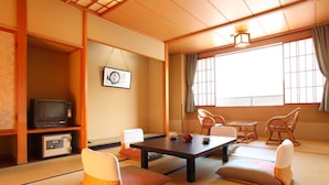 A traditional Japanese room with tatami flooring, a low table, and cushions.