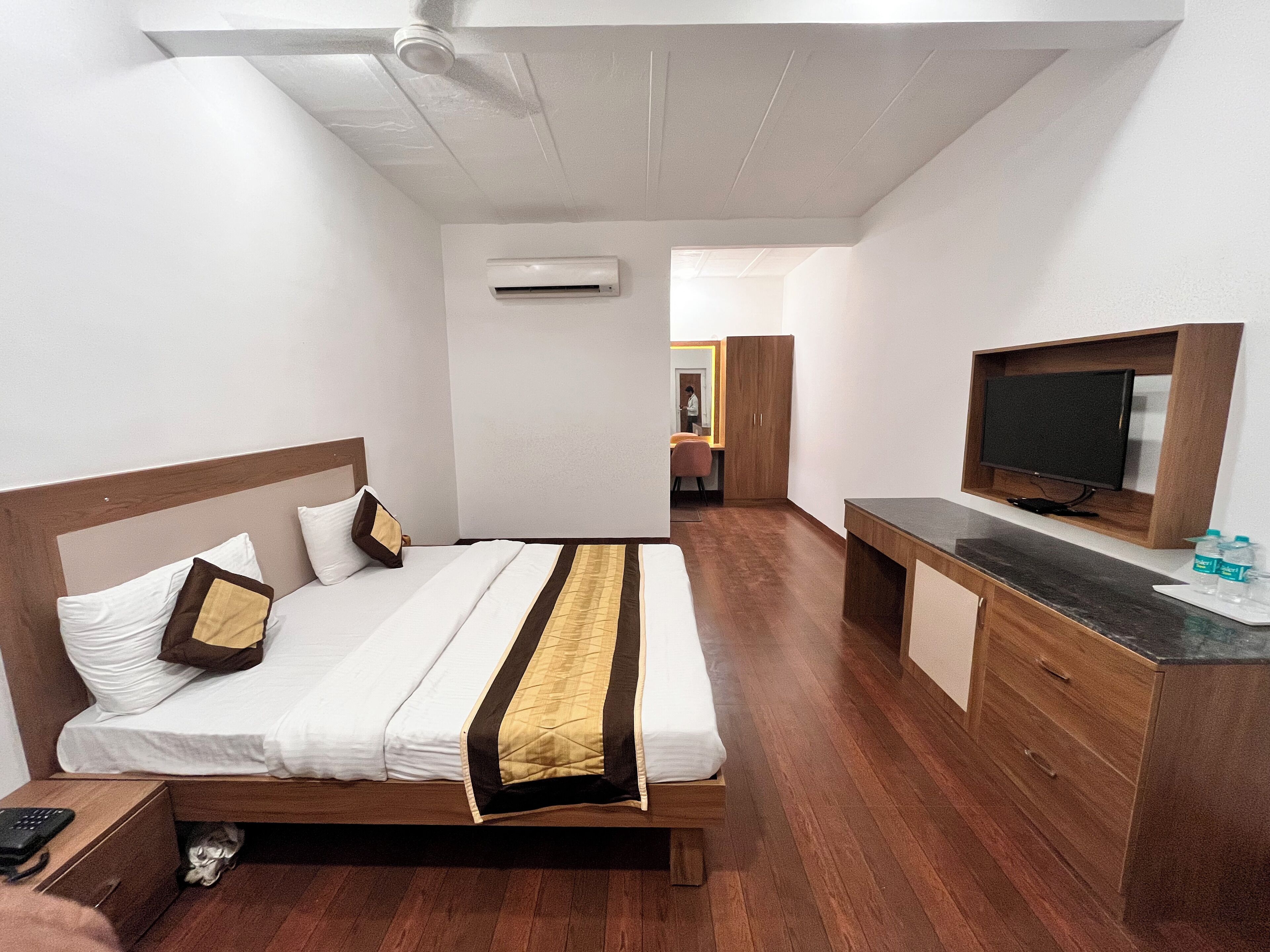 A hotel room with a bed, a TV, a desk, and a wardrobe.