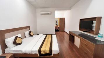 A hotel room with a bed, a TV, a desk, and a wardrobe.