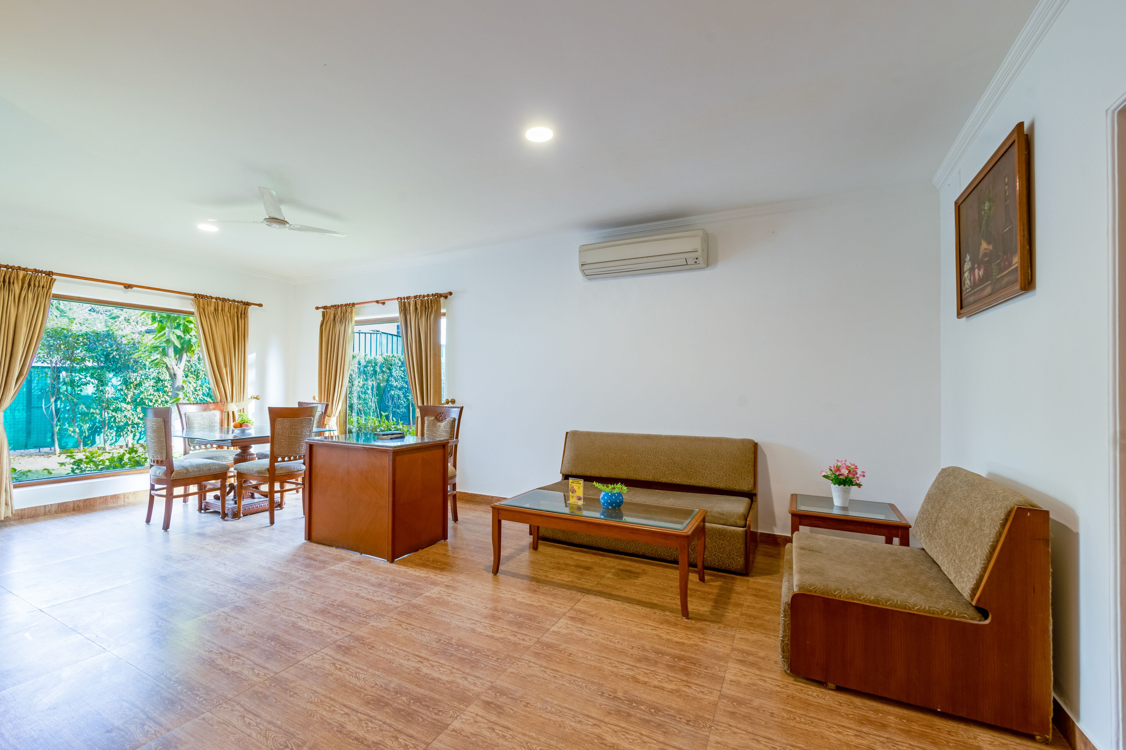 A living room with a sofa, coffee table, and dining area with chairs.