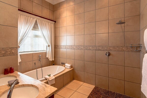 Une salle de bain avec une baignoire, une douche et un lavabo.