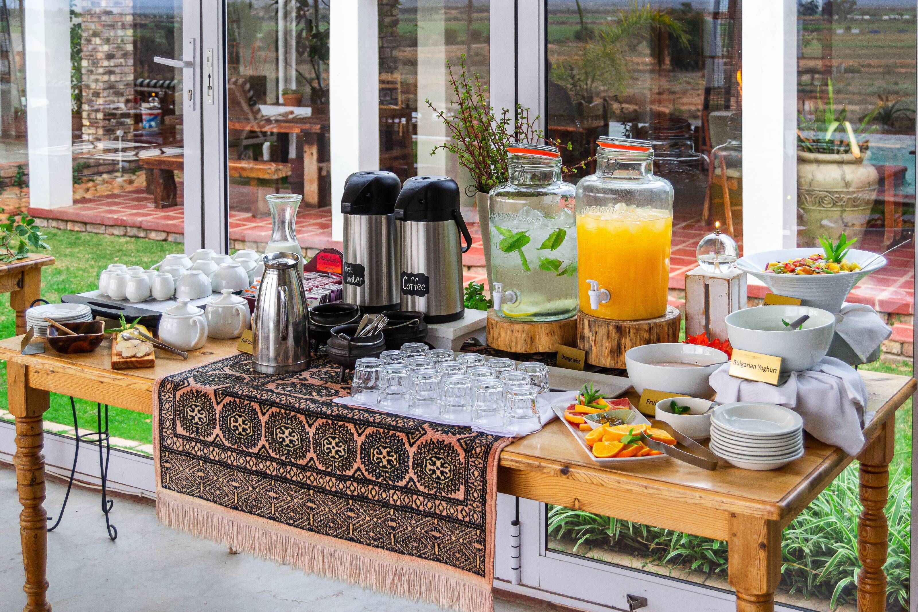 A breakfast buffet with various food items, beverages, and utensils.