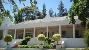A white building with a covered porch and a well-maintained lawn. - Diemersfontein Wine and Country Estate (Wellington)