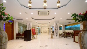A spacious lobby with a marble floor, ornate columns, and a central reception area. - Lilypool - The Heritage Jalmahal (Jaipur)