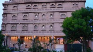 A multi-story building with a symmetrical facade, multiple balconies, and a series of windows. - Lilypool - The Heritage Jalmahal (Jaipur)