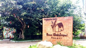 A sign for Baan Chokadee Resort with a house and tree graphic. - Baan Chokdee Pai Resort (Pai)