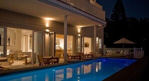 Una piscina al aire libre, sombrillas, tumbonas
