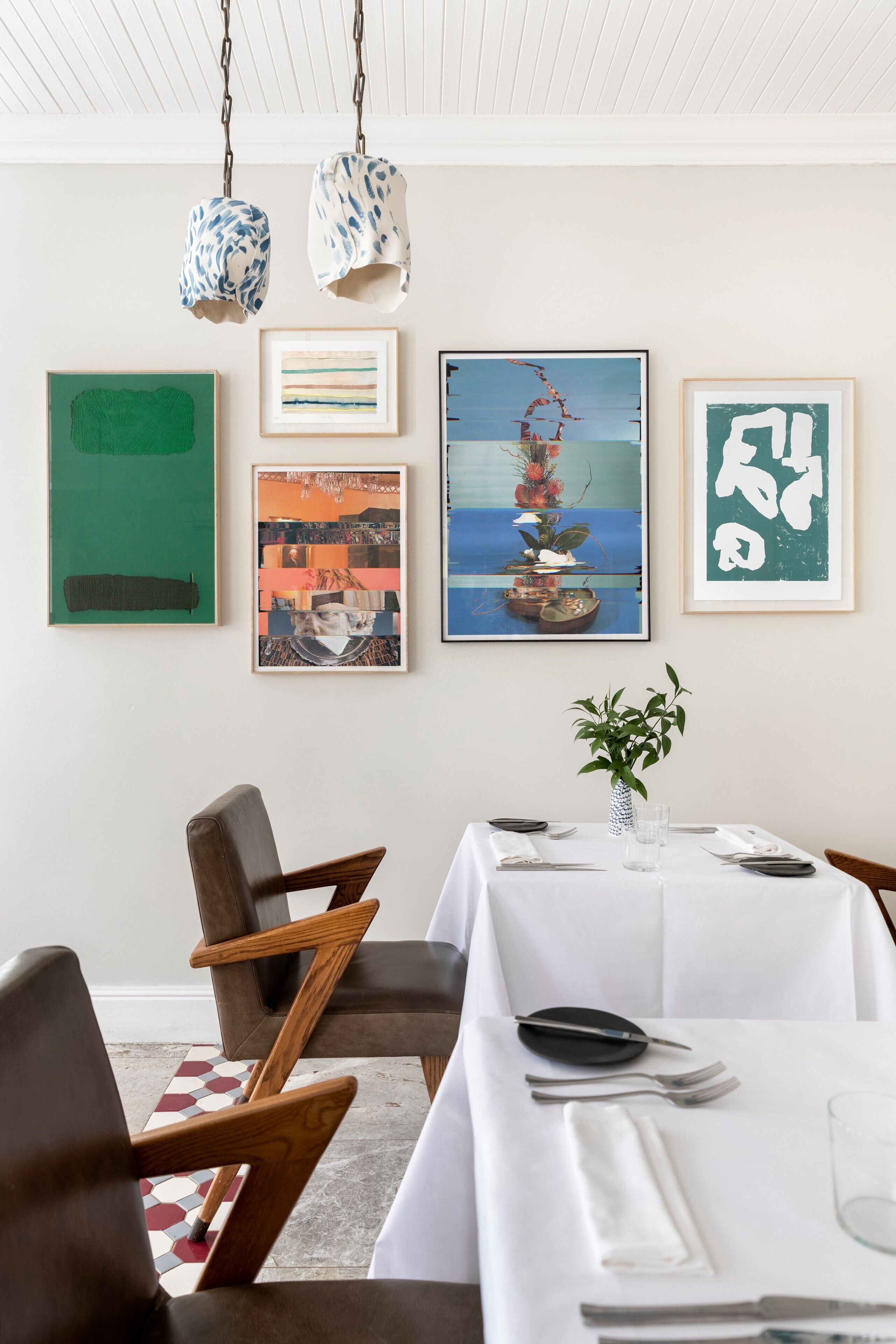 Un comedor con una mesa blanca dispuesta para cuatro personas, rodeada de sillas de madera.