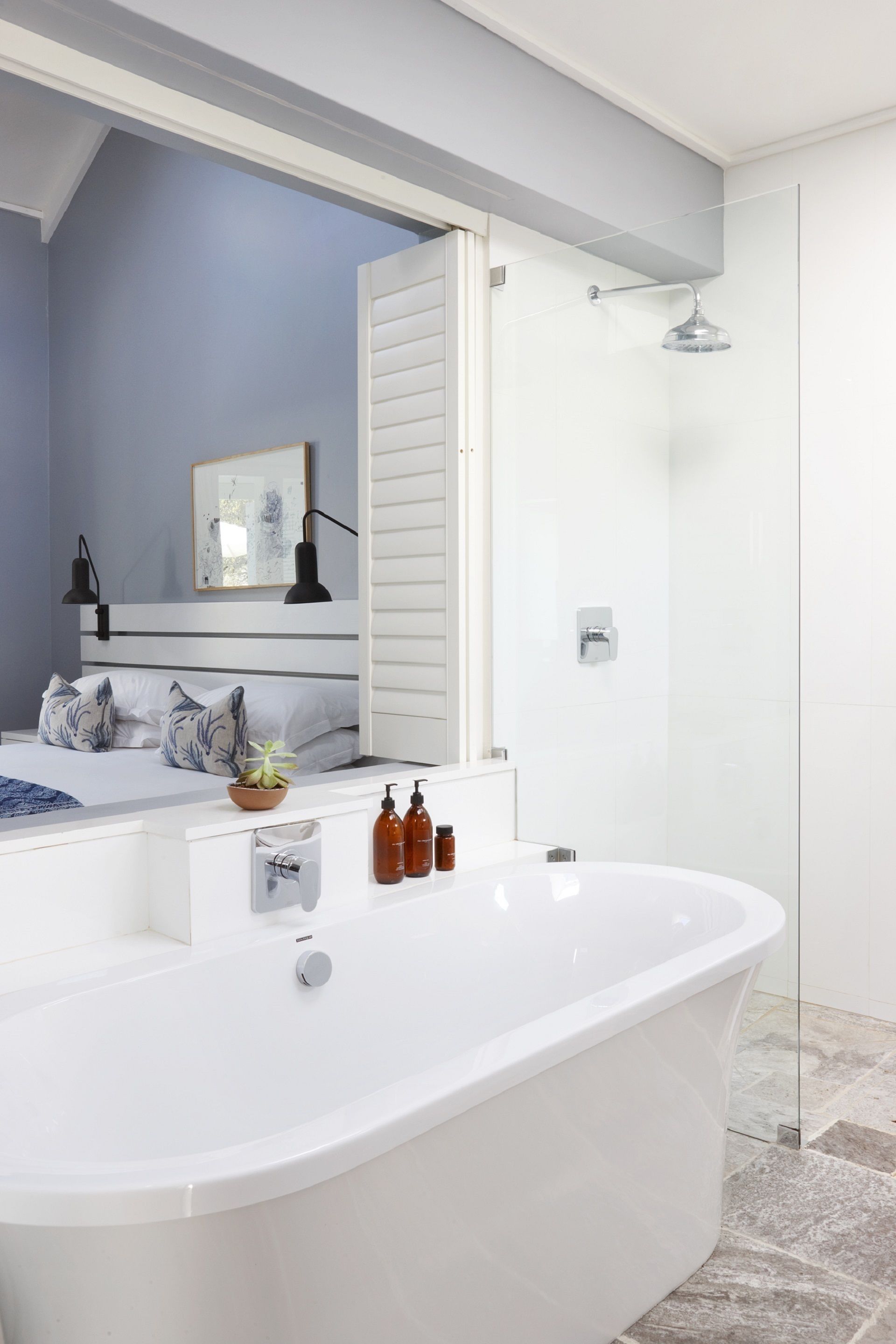 Une salle de bain moderne avec une baignoire sur pieds, une douche à parois de verre et un meuble-lavabo blanc avec un miroir.