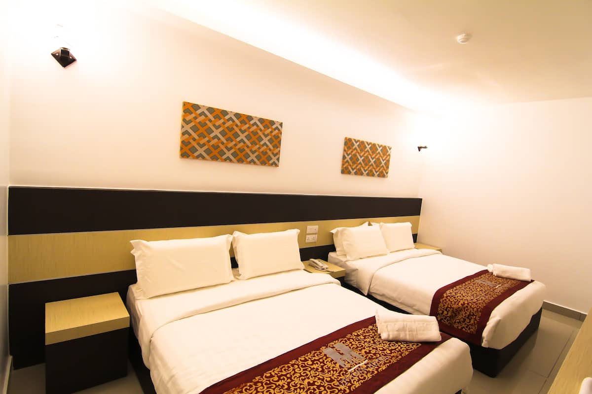 A hotel room with two beds, a nightstand, a telephone, and decorative wall art.