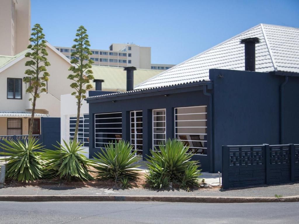 A building with a dark facade, large windows, and a metal roof.