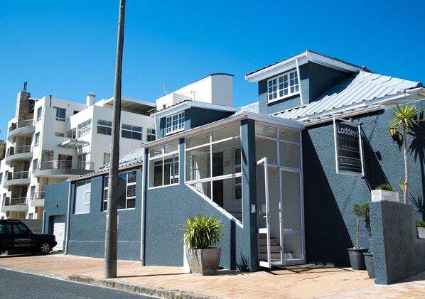 A modern building with a glass entrance, a staircase, and a sign for 'Loddey's'. - Loddeys Guesthouse (Cape Town)