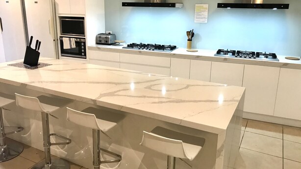 A modern kitchen with a marble countertop, stainless steel appliances, and white cabinetry. - Cityview Studio Accommodation (Leichhardt)